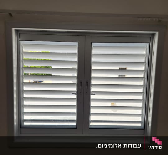 חלון אלומיניום לבן בודד עם תריס שלבים מותקן בקיר